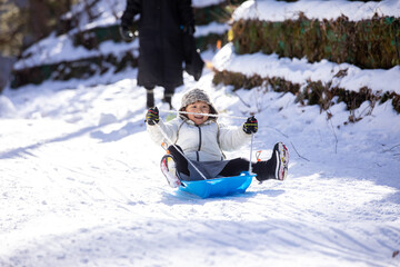 ゲレンデでそり滑りをする男の子
