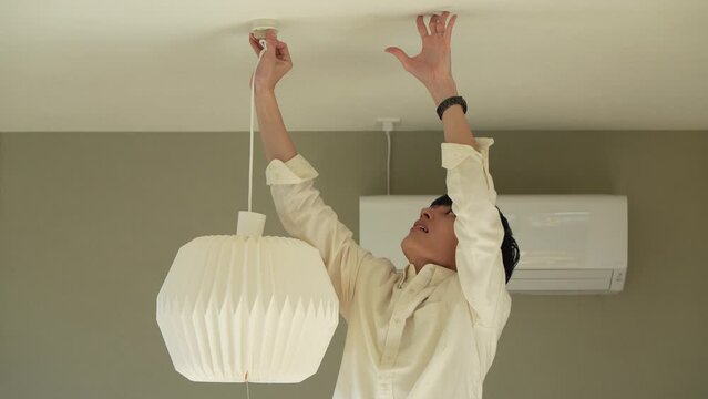 照明器具を取り付ける男性