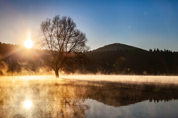 Sunrise above the misty lake