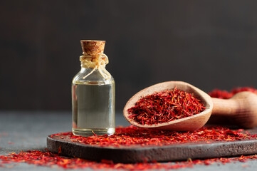 Glass bottle of saffron essential oil with dried saffron, spice or herb oil concept, alternative...