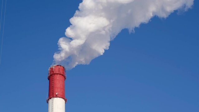 Powerful emissions into the atmosphere from the chimney of a thermal power plant in winter