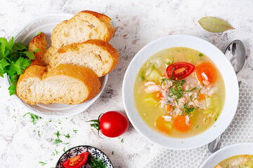 Fish soup with salmon, vegetables and rice in white bowl. Top view, above