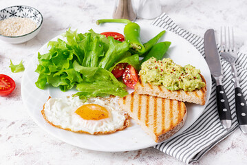 Fried egg, fresh salad and avocado guacamole sandwiches. Concept of a healthy lifestyle
