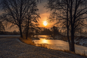 Krajobraz zimowy. Widok ze wschodem słońca i zimowy poranek nad rzeką. Zamrożona rzeka. Świtanie w zimowej scenerii. Mroźny poranek. Tło natury.	 - obrazy, fototapety, plakaty