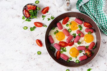 Homemade delicious american breakfast with  fried eggs,  sausages, and tomatoes. Concept of a healthy lifestyle. Top view