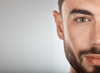 Face, beauty and eye of a man with clean, glow and healthy skin on a grey studio background for...