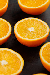 Fresh orange halves on a dark background. Juicy citrus fruits for making juice
