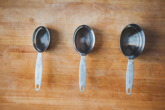 Overhead view of measuring cups arranged on wooden table