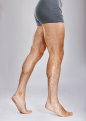 Man, legs or muscles on studio background for fitness check, workout training goals or studio exercise wellness. Underwear model, bodybuilder and strong athlete feet on gray backdrop for healthcare