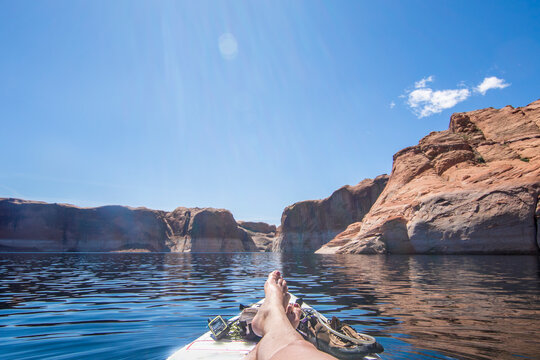 Woman relaxing on paddle board, Lake Powell, Utah, USA