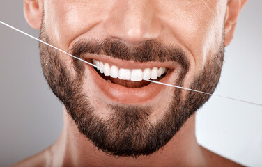 Dentist, floss and mouth of man with smile on gray background in studio for wellness, healthcare...