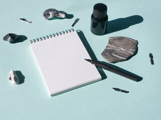Mockup of white notebook for sketch, artwork, calligraphy on blue background. Mint desk work with...