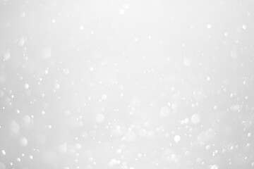 White glitter vintage lights background.  White bokeh shiny on dark background.