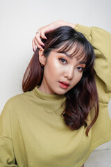 Naklejka premium A beauty cheerful face of Asian young model wearing green top. Skincare beauty facial treatment, spa, female health concept.