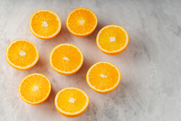 Halves of ripe oranges on gray background. Sliced oranges on concrete. Copy space