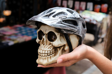 Crop woman showing skull with helmet