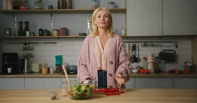 Mature woman tells recipe of fresh vegan salad for breakfast