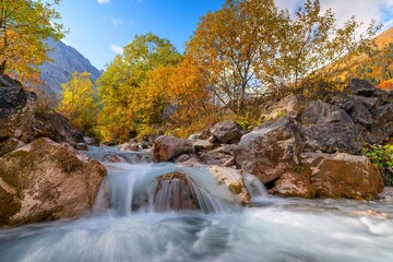 Flie&szlig;ender Gebirgsbach im Herbst bei Sonnenschein