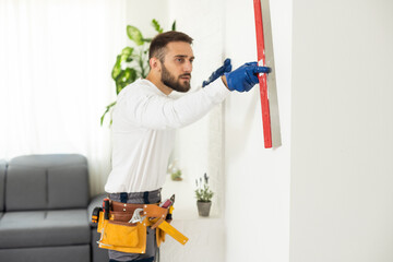 Construction worker are using sponge and plastering trowel to smooth the walls. Home improvement,...