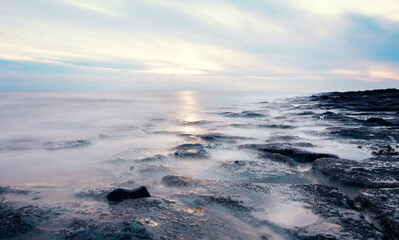 Fototapeta na wymiar beautiful sun rise over the rocky coast in winter