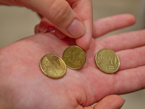 Girl holds euro coins of 10 and 20 cents in hand