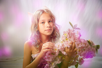 Portrait of cute kid girl posing in pink beautiful dress on a white background. Model in studio looking as gentle magic princess from fairy taly