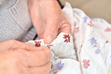 裁縫をする高齢女性の手元