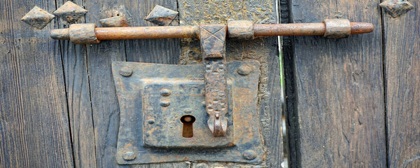 Old , ancient lock and bolt on distressed door 