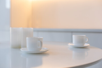 White cup on the kitchen table in the background