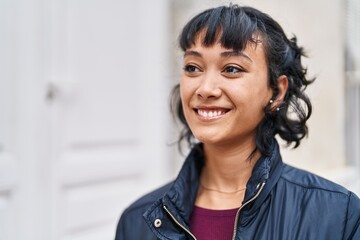 Young beautiful hispanic woman smiling confident looking to the side at street