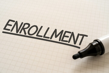 ENROLLMENTと書かれたノートとマーカー