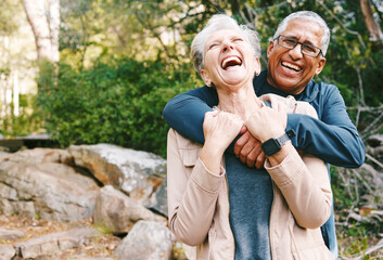 Hiking, laugh and romance with a senior couple hugging while in the woods or nature forest together...