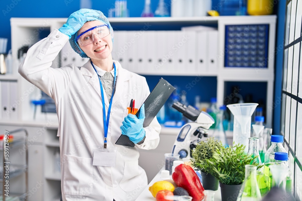 Sticker Beautiful woman working at scientist laboratory with food stressed and frustrated with hand on head, surprised and angry face