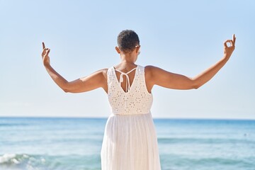 Fototapeta na wymiar African american woman doing yoga exercise at seaside