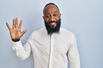 Obraz premium African american man standing over blue background showing and pointing up with fingers number five while smiling confident and happy.