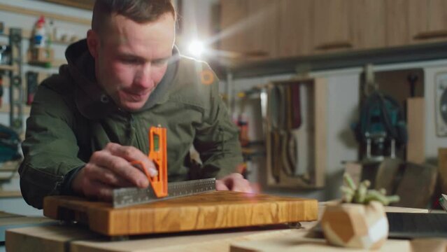 Carpentry. A small carpentry business owner inspects a product before selling it