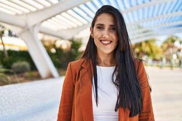 Young hispanic woman smiling confident walking at street