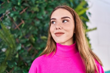 Fototapeta premium Young woman smiling confident looking to the side at park