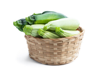 Freshly harvested courgette and zucchini in wicker basket isolated on white