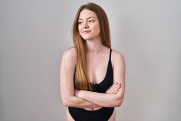Young caucasian woman wearing lingerie smiling looking to the side and staring away thinking.