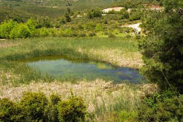 View of Rapentosa dam lake with beautiful horses and young girls equestrians, Greece