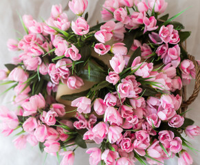 flowers in wicker basket on white wooden table, space for text. Spring blossom