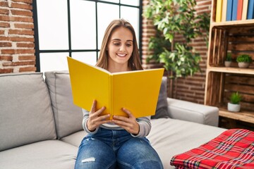 Young blonde woman smiling confident reading book at home