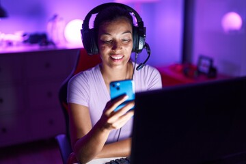 Young beautiful hispanic woman streamer using computer and smartphone at gaming room © Krakenimages.com