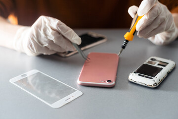 Technician repairing inside of mobile phone by soldering iron. the concept of data, hardware,...