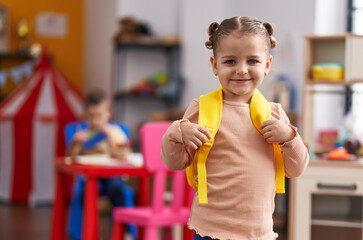 Adorable hispanic girl student smiling confident wearing backpack at kindergarten