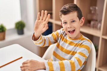 Blond child saying hello sitting on table at home © Krakenimages.com