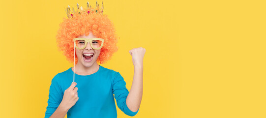 cheerful selfish child girl in curly wig and princess diadem wear party glasses, success. Funny teenager child in wig, party poster. Banner header, copy space.