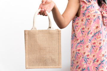 Brown sackcloth bag is held by the right hand of asian woman