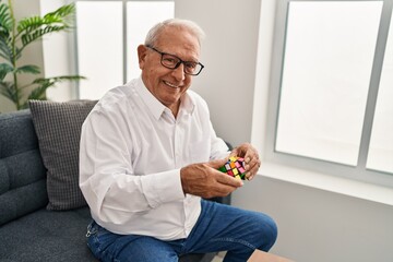 Senior man psychologist smiling confident playing mental game at psychology center